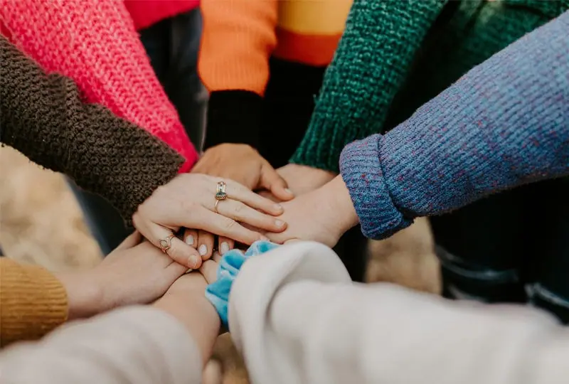Community members joining hands together